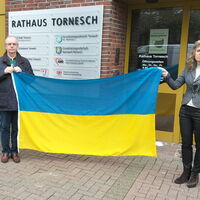 Bild vergrößern: Bürgervorsteher und Bürgermeisterin mit Ukraine-Flagge